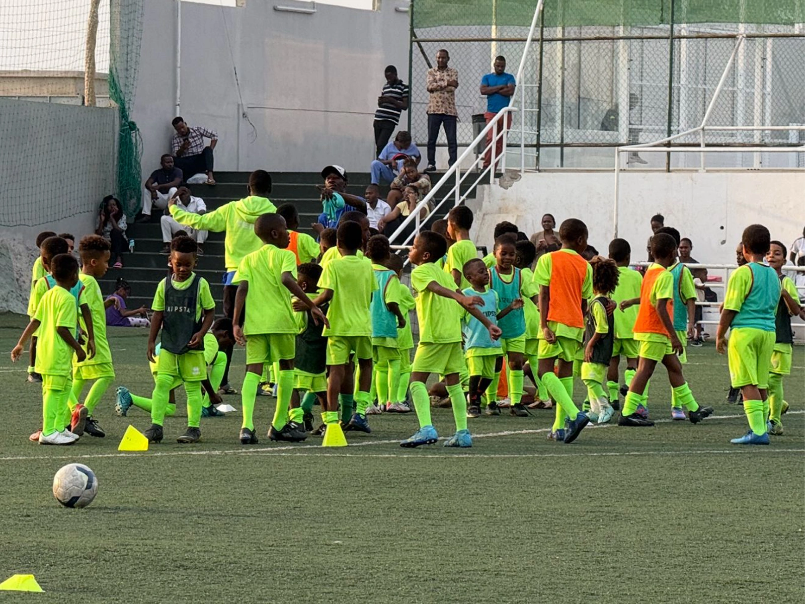 Jovens atletas da escola de futebol a treinar no campo do Decifer